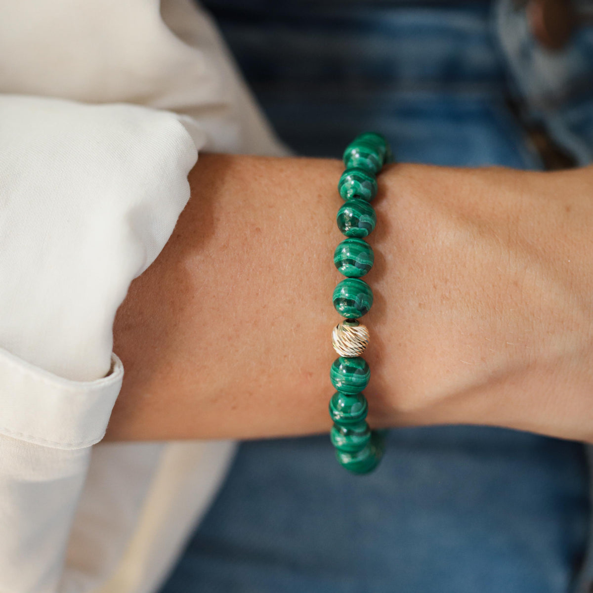 Close-up of 8mm malachite beads with 14K gold accents from Earthly Abundance jewelry collection.