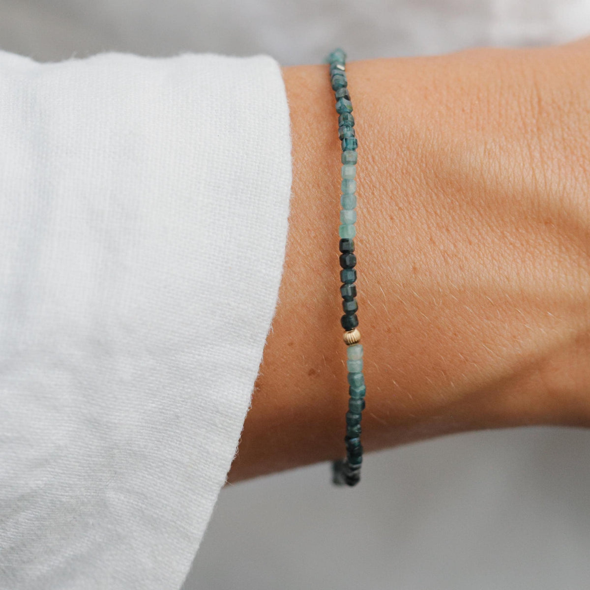 Earthly Abundance Grandidierite cube bracelet featuring striking blue-green gemstones on a delicate silver chain