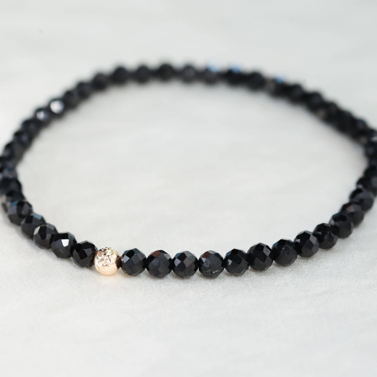 Black Tourmaline bracelet with 4mm beads from Earthly Abundance Jewelry, showcasing a stylish 14K bracelet with polished stones.