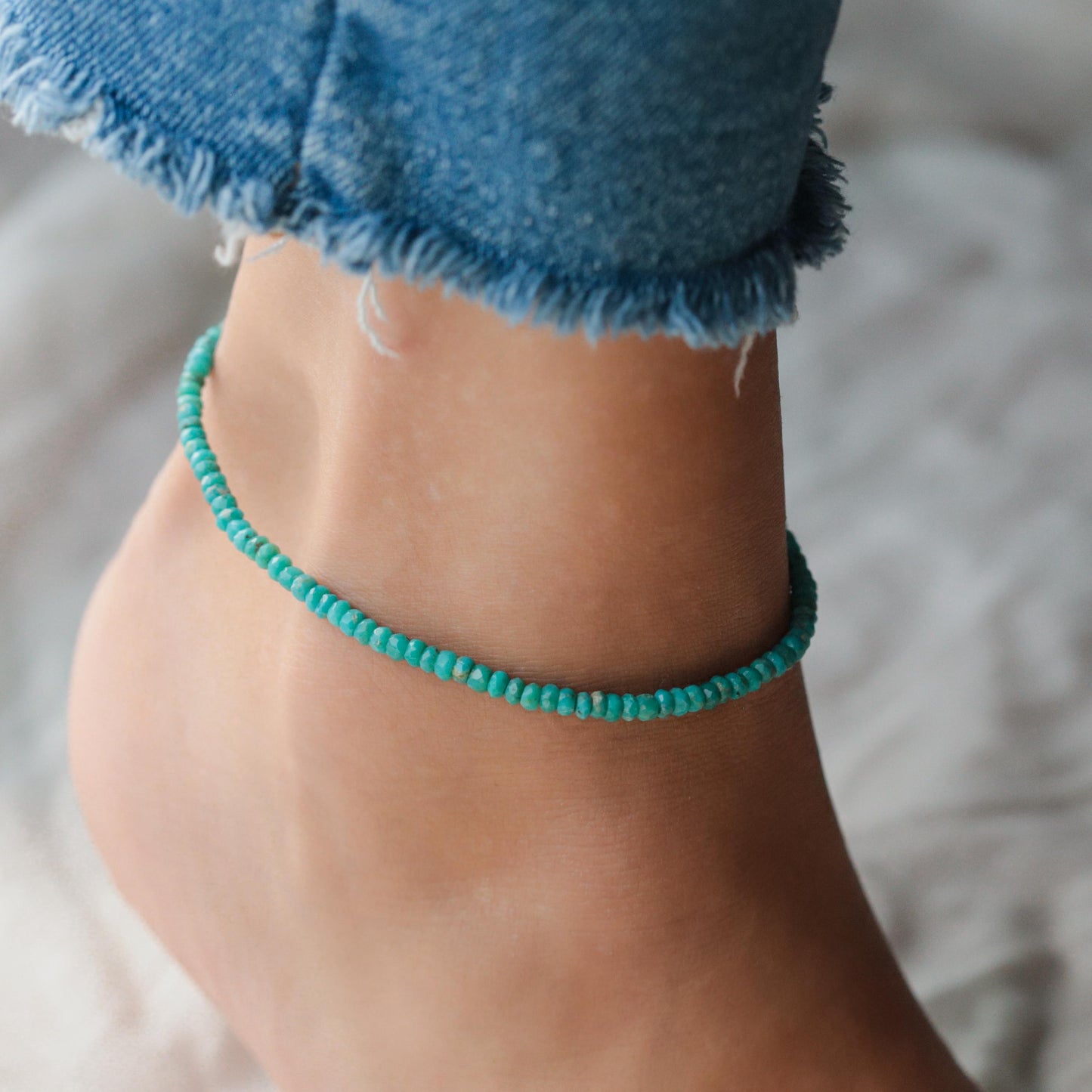 Turquoise anklet from Earthly Abundance featuring a delicate silver chain with turquoise beads, worn around the ankle.