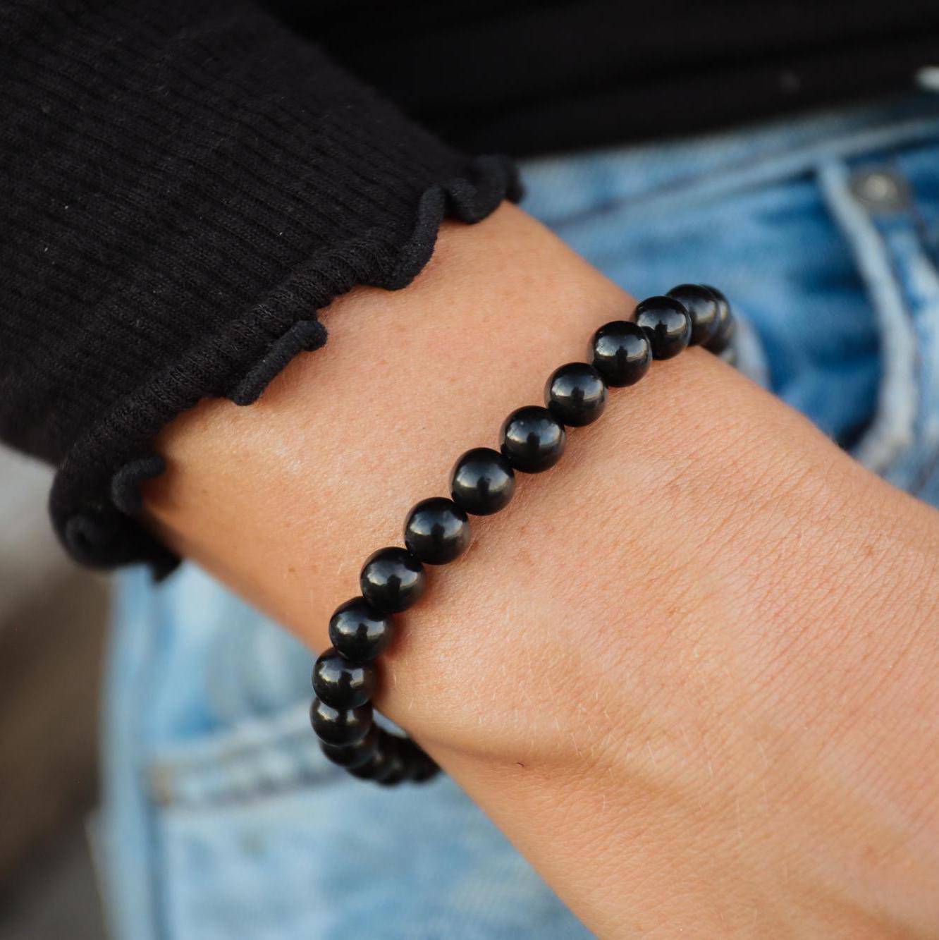 Shungite 6mm gemstone beads from Earthly Abundance Jewelry, showcasing round black stones with a polished finish.