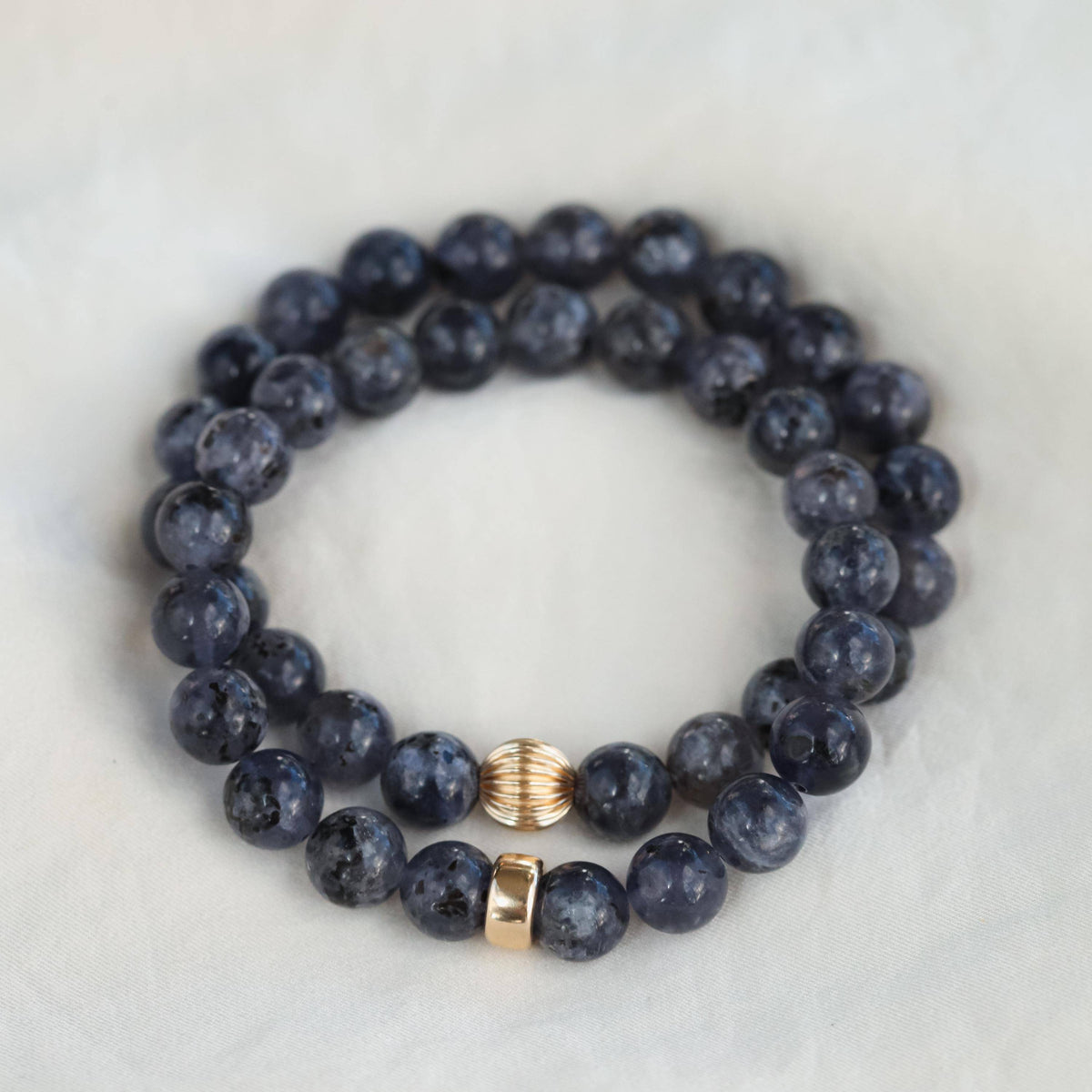 Iolite bracelet with 14K gold setting from Earthly Abundance Jewelry, showcasing smooth, oval-shaped blue gemstone beads.