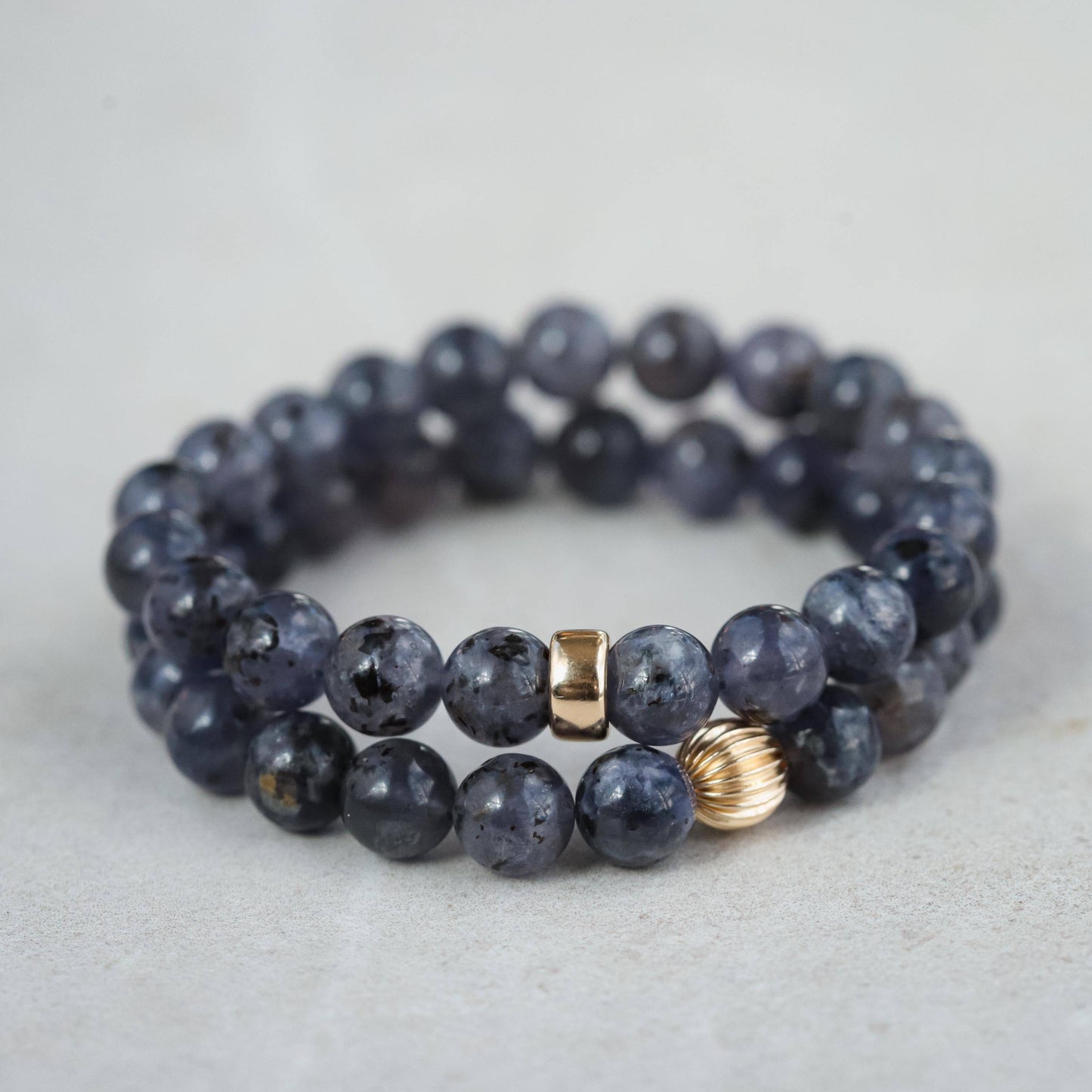 Iolite bracelet featuring 14K gold accents from Earthly Abundance Jewelry, showcasing polished blue-purple stones on a delicate chain.
