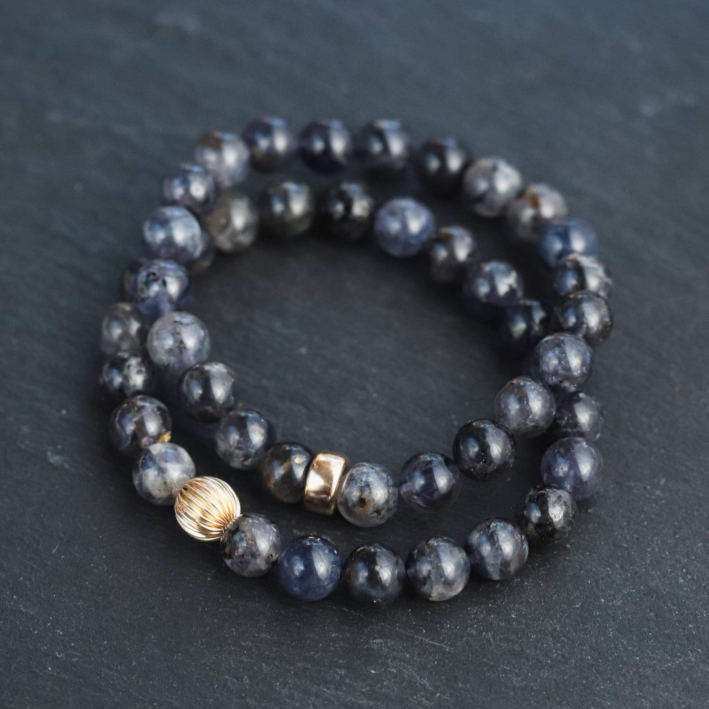 Iolite bracelet with 14K gold setting from Earthly Abundance Jewelry, featuring deep violet-blue gemstones on a delicate chain.