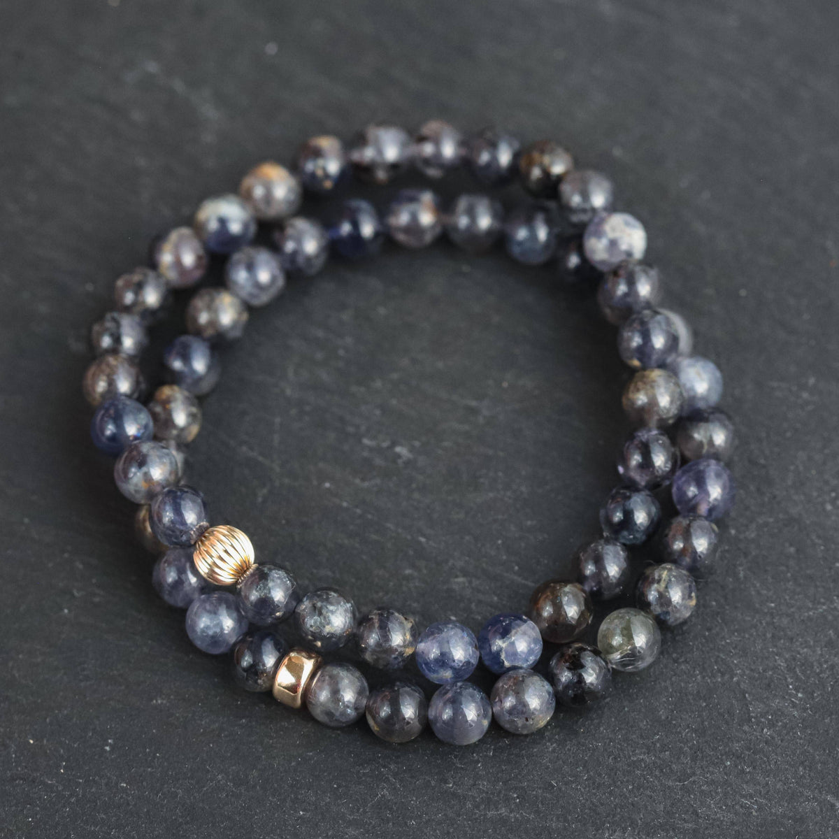 Iolite bracelet featuring 14K gold accents from Earthly Abundance Jewelry, showcasing polished blue-purple stones on a delicate chain.