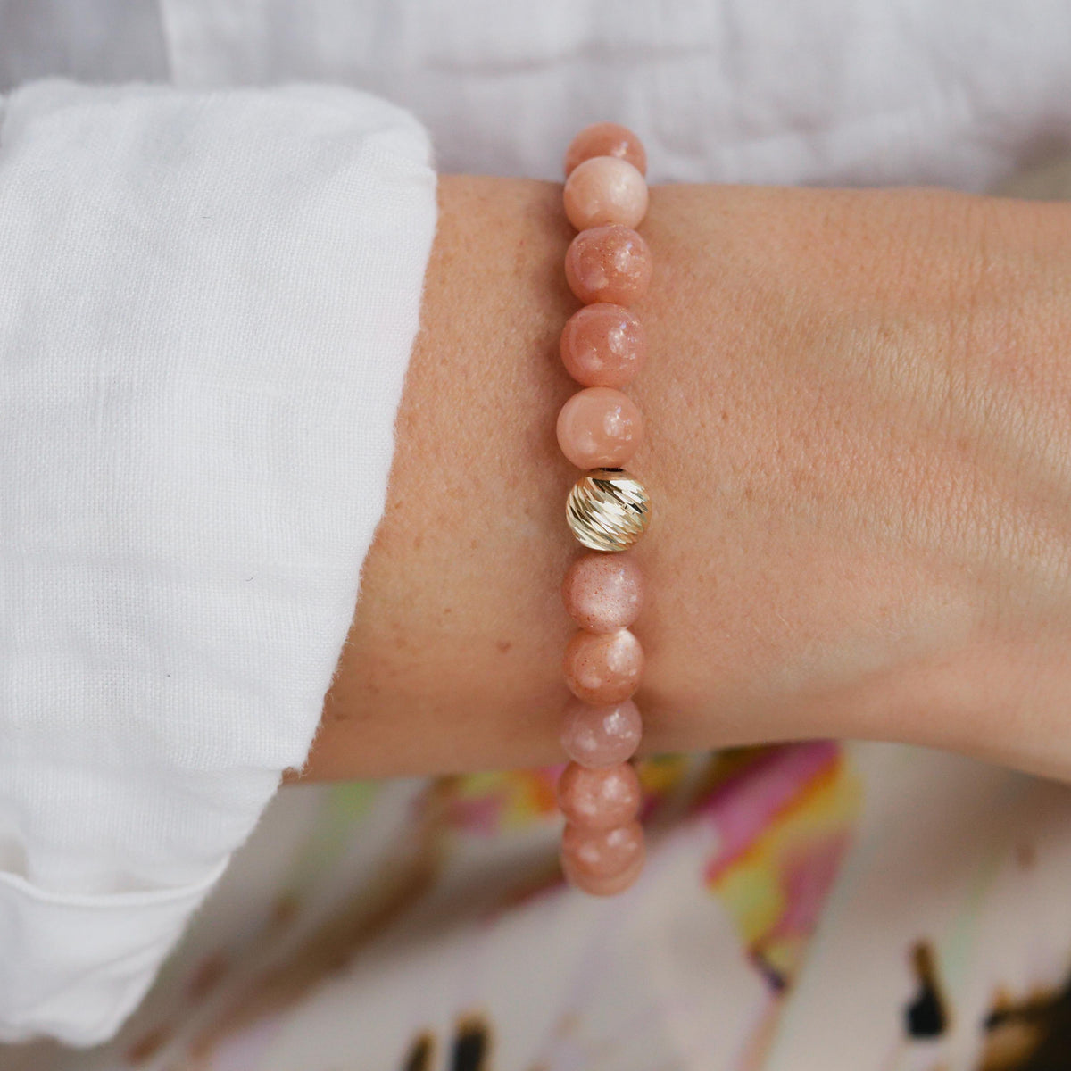 Paloma Peach Moonstone bracelet by Earthly Abundance featuring peach and iridescent moonstone beads on a delicate string.