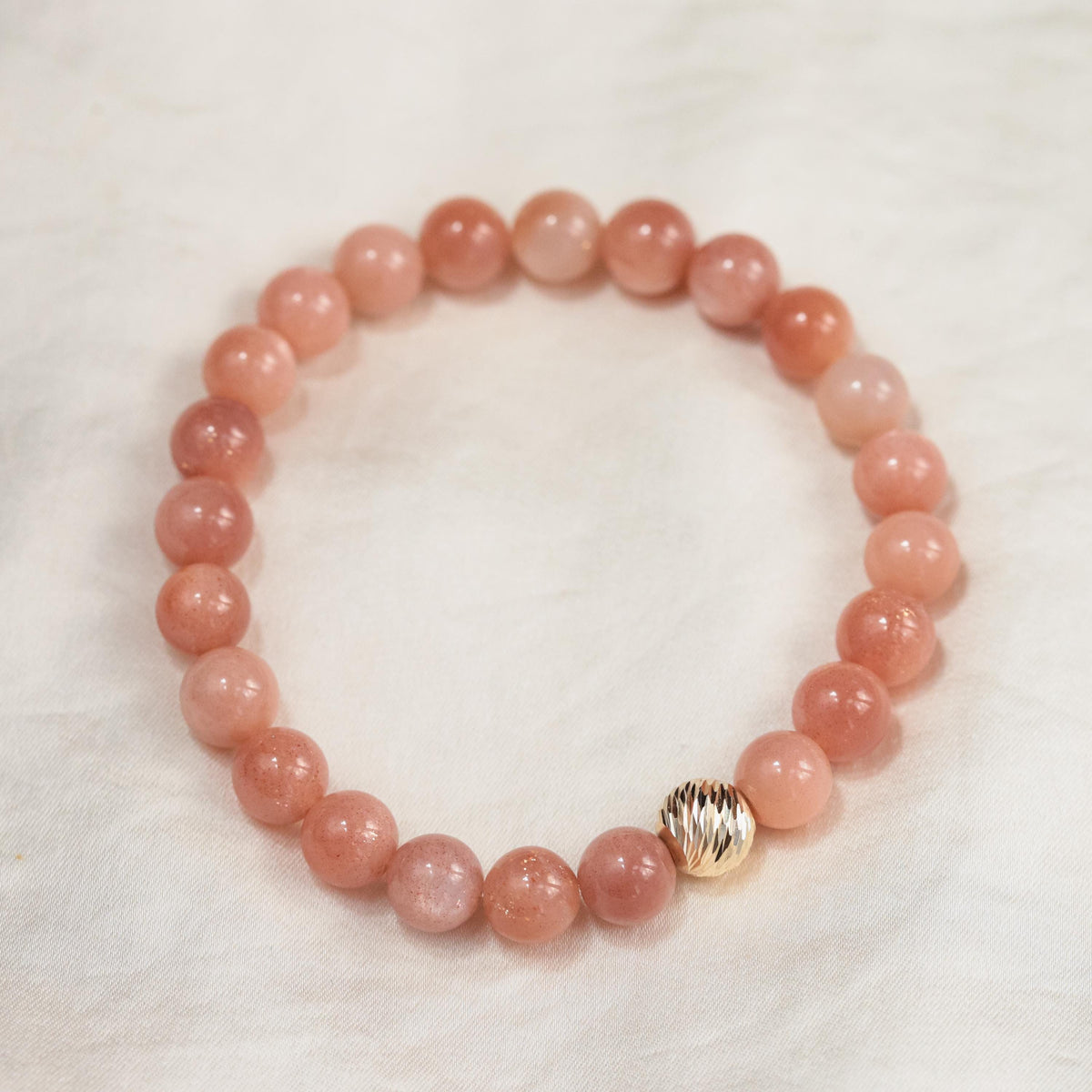 Paloma Peach Moonstone bracelet by Earthly Abundance featuring peach moonstone beads and silver accents.