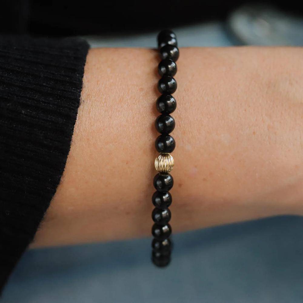 Shungite 6mm gemstone strand from Earthly Abundance Jewelry featuring polished black stones on a string.