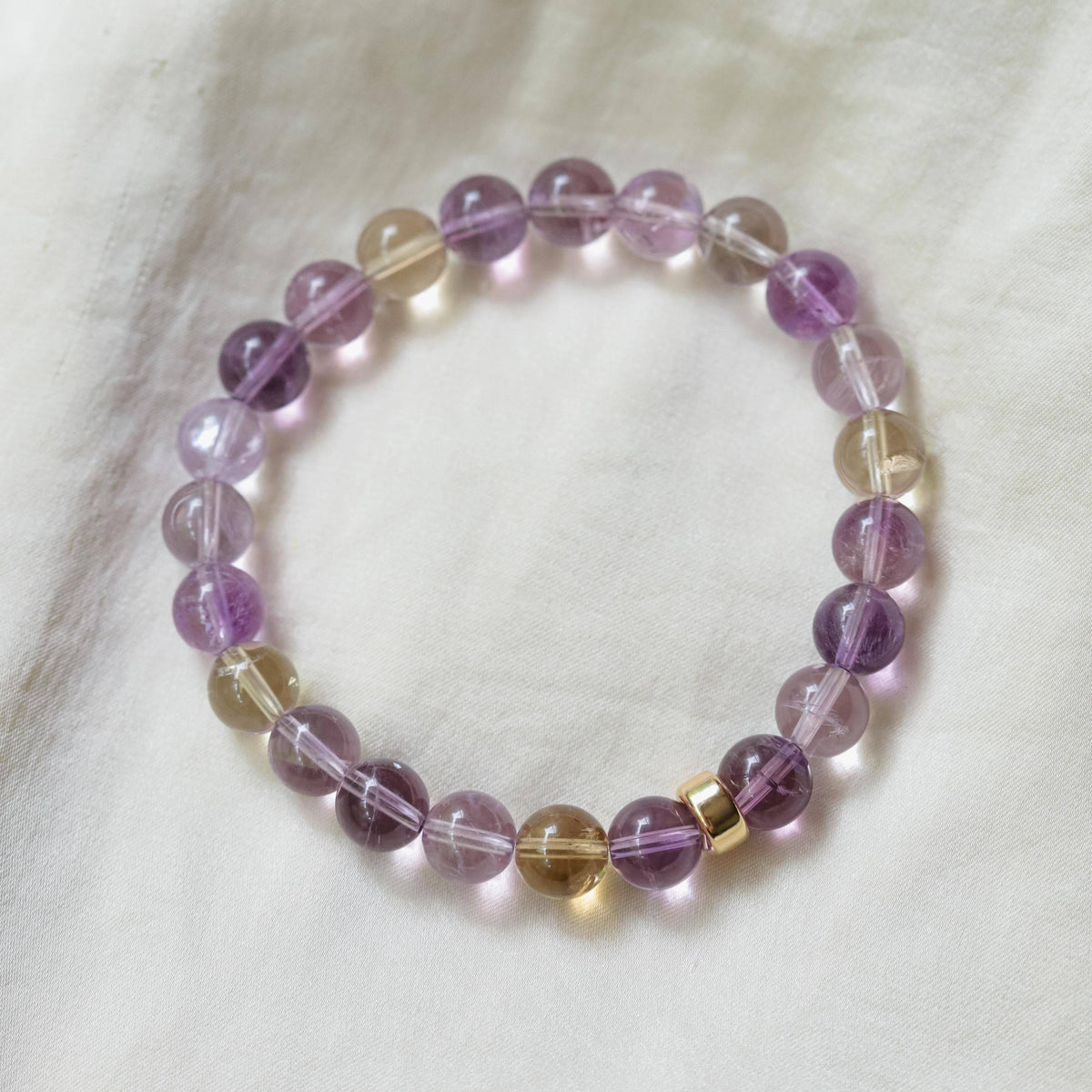 Ametrine bracelet featuring 14K gold setting from Earthly Abundance Jewelry, with polished purple and yellow gemstone beads.