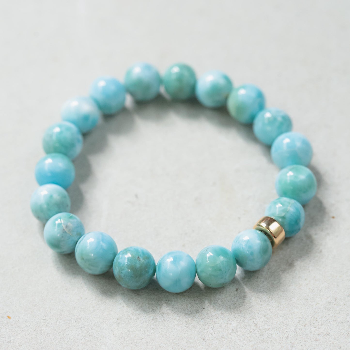 Larimar bracelet with 10mm beads and 14K accents from Earthly Abundance, featuring smooth blue and white gemstone stones.