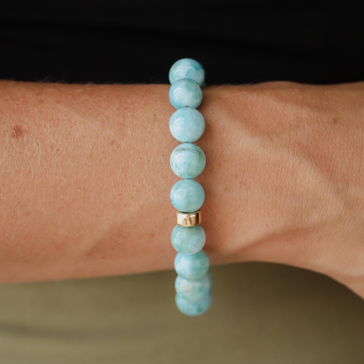 Larimar bracelet with 10mm beads featuring 14K gold accents, crafted by Earthly Abundance, showcasing vibrant blue stones.