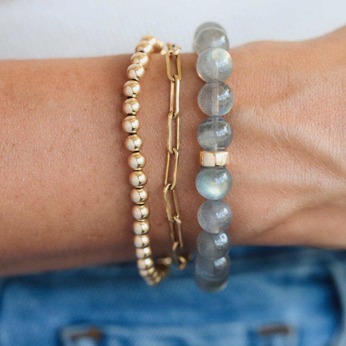 Labradorite bracelet featuring 9mm stones with a 14K clasp, showcasing iridescent blue and green hues on a delicate jewelry piece.