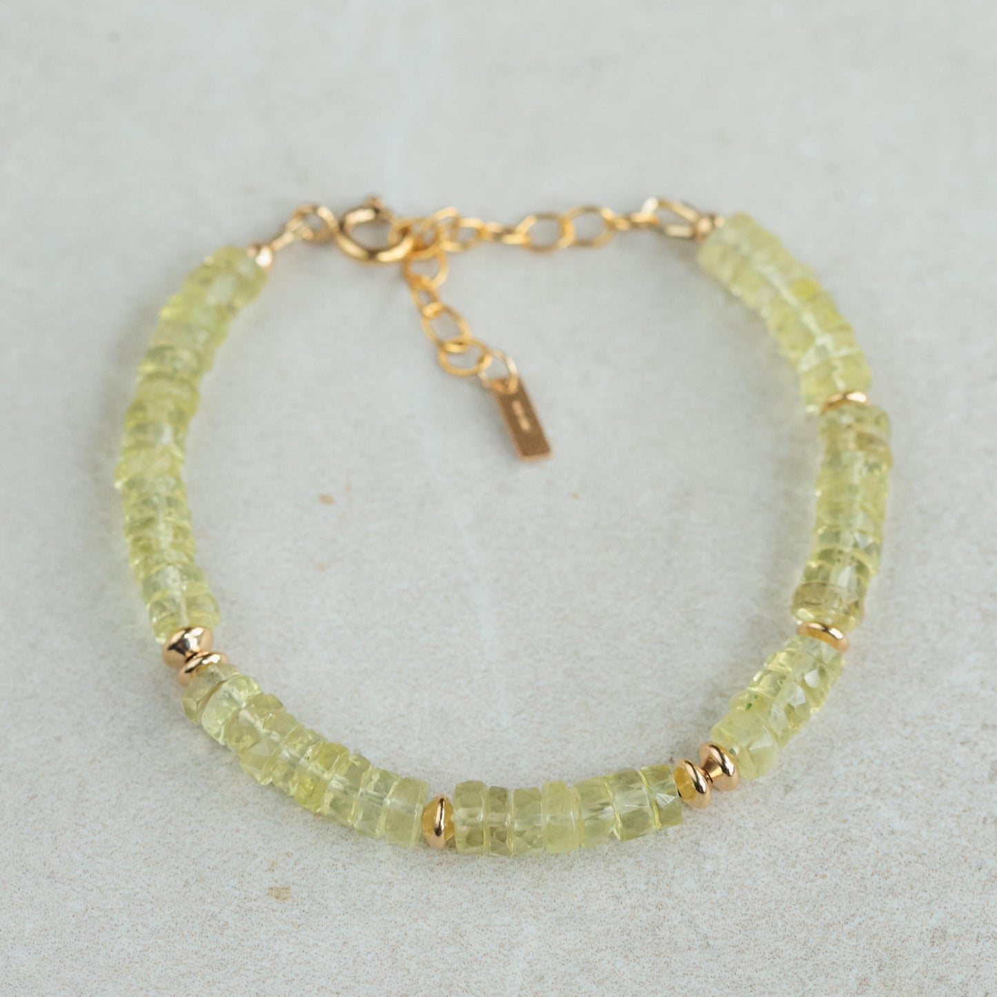 Natural lemon quartz bracelet with smooth yellow stones on an elastic band, showcasing earthy and vibrant gemstone jewelry.
