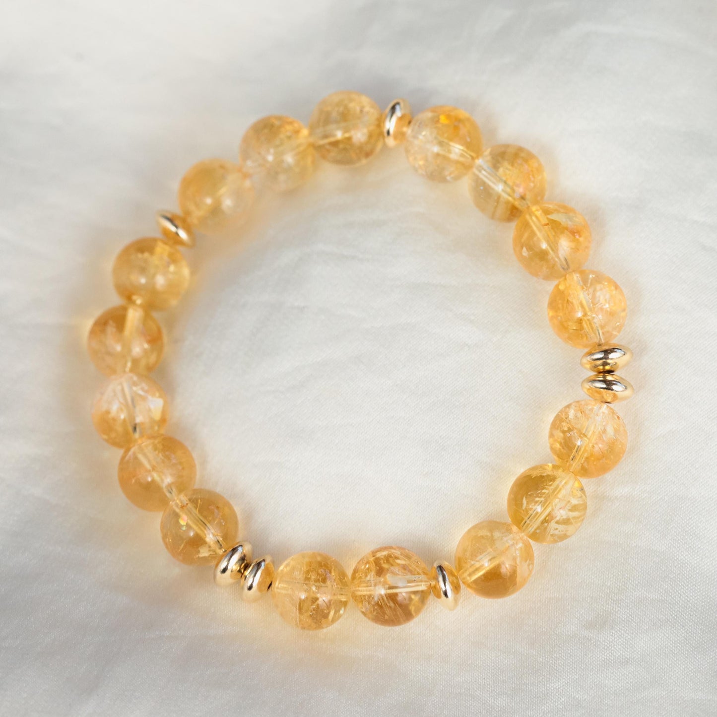 Earthly Abundance Citrine 10mm bracelet featuring polished round citrine gemstones on an elastic band, close-up view.