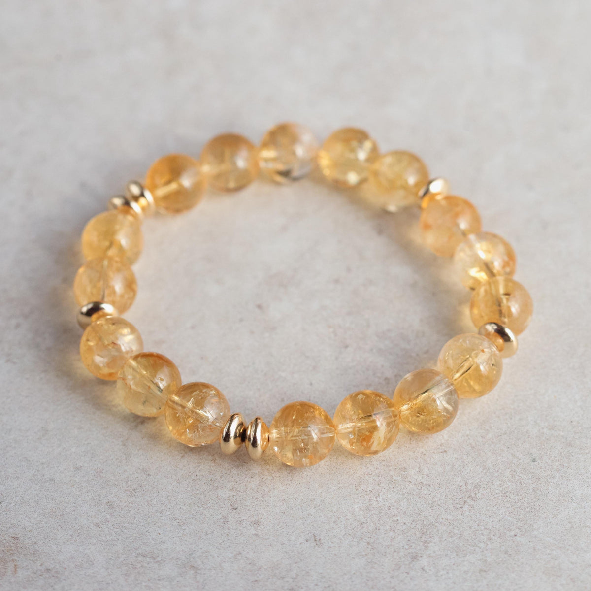 Earthly Abundance citrine 10mm bracelet featuring polished yellow gemstone beads on an elastic cord.