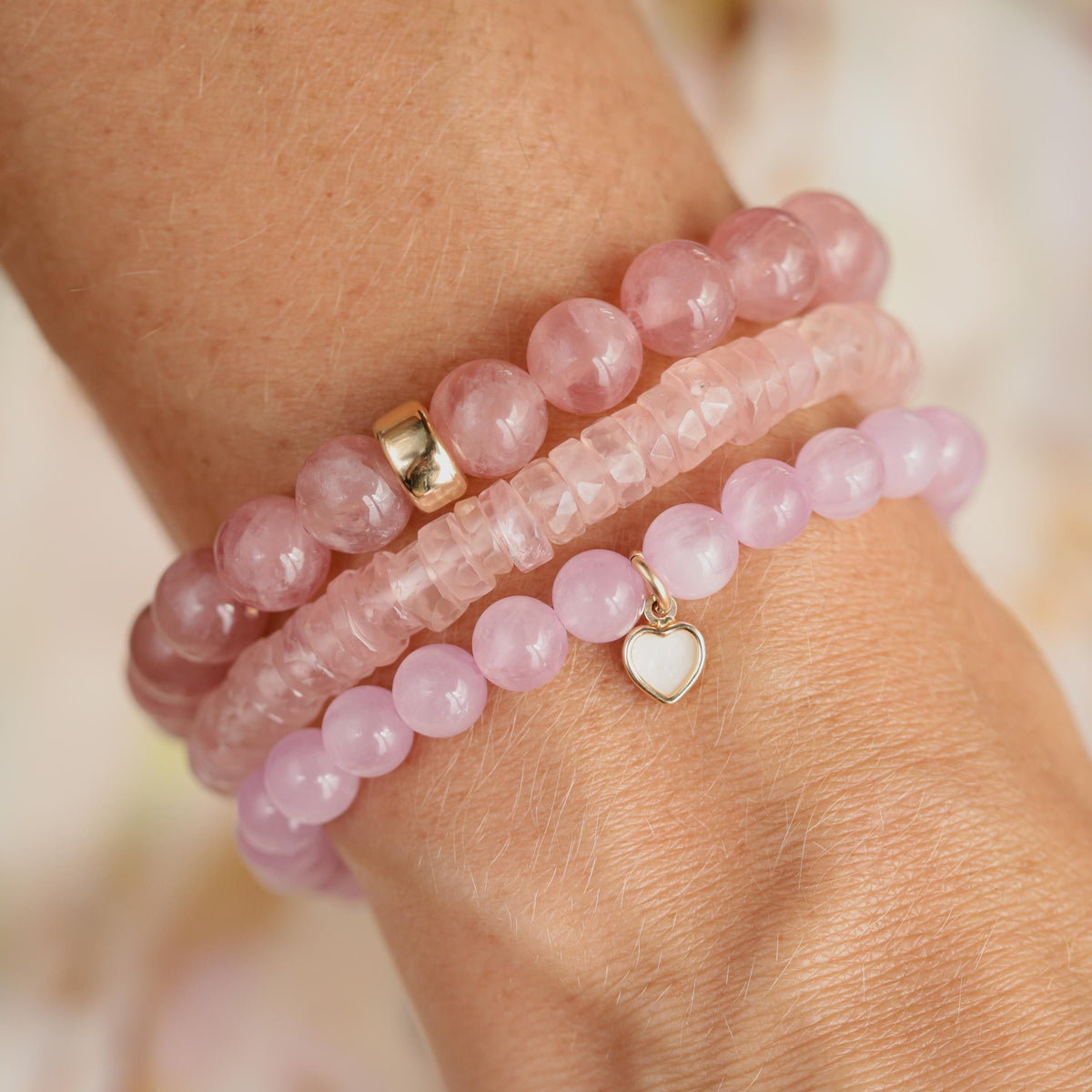 Earthly Abundance Rose Quartz Heishi bracelet with small pink stone beads strung on elastic cord, close-up view of the jewelry.