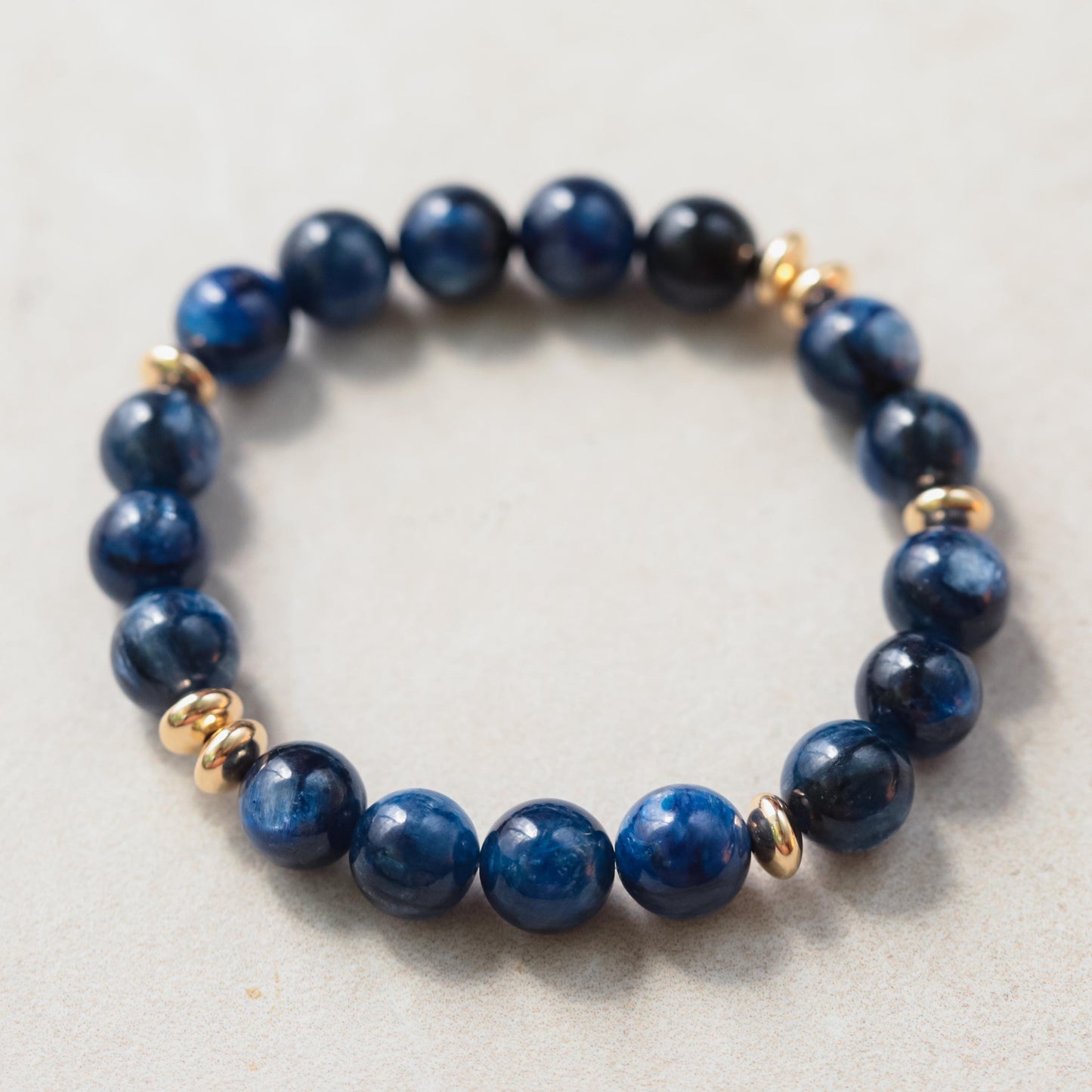 Kyanite bracelet with 10mm beads from Earthly Abundance Jewelry, featuring blue and green hues on a plain background.