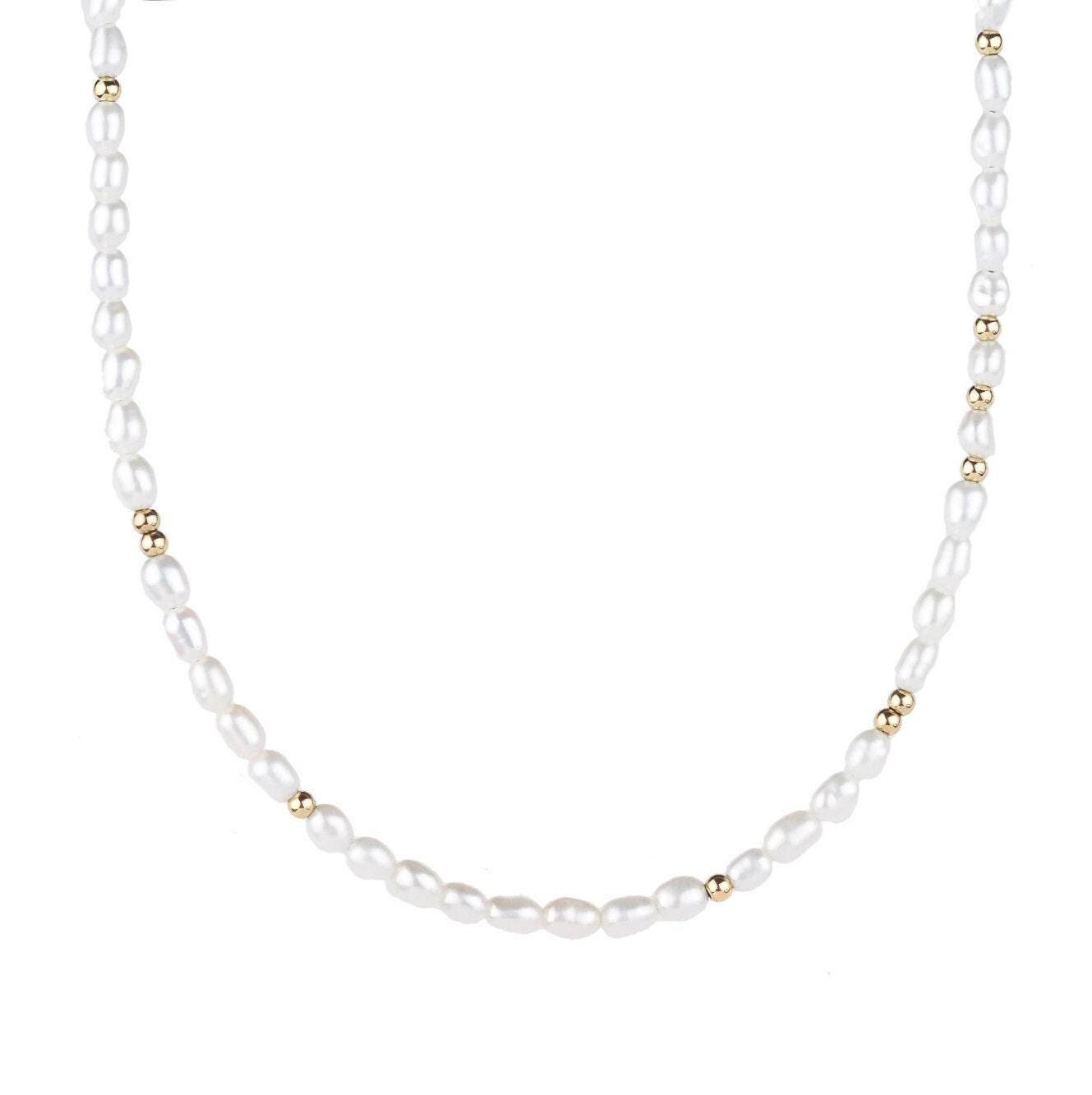 Freshwater pearl necklace with 14K gold clasp from Earthly Abundance Jewelry, featuring lustrous white pearls on a delicate chain.