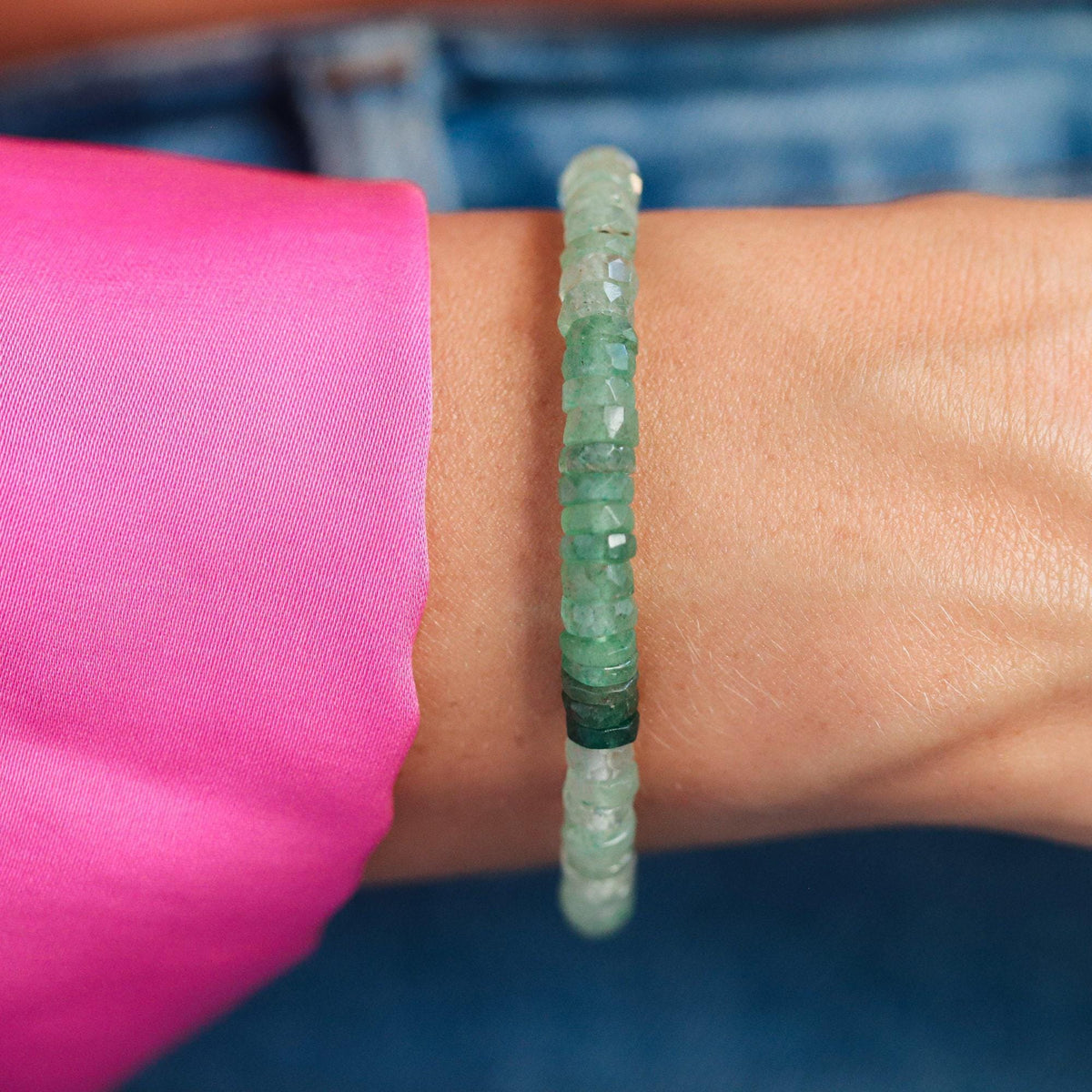 Green strawberry quartz Heishi bracelet from Earthly Abundance with smooth, round gemstone beads on an elastic band.