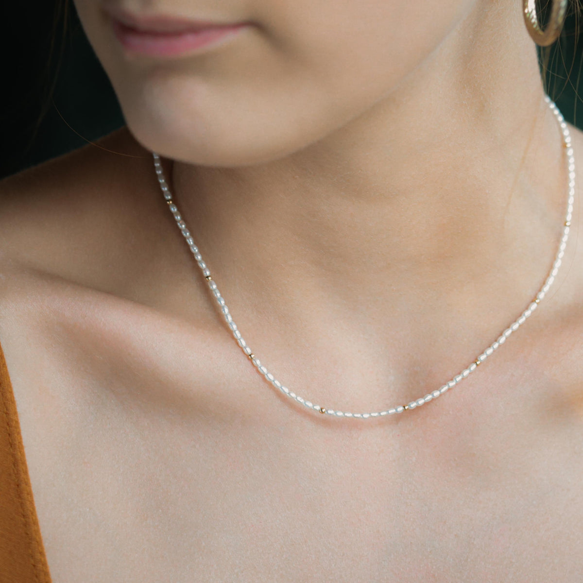Freshwater pearl necklace with 14K gold clasp from Earthly Abundance, showcasing lustrous white pearls on a delicate chain.