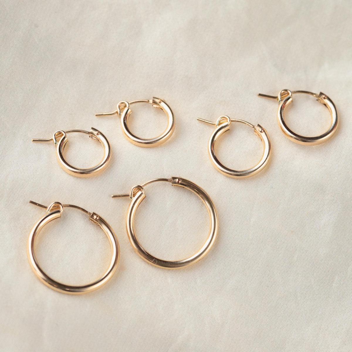 14K gold-filled Effortless Hoops earrings by Earthly Abundance, featuring smooth, polished gold hoops with a secure clasp.