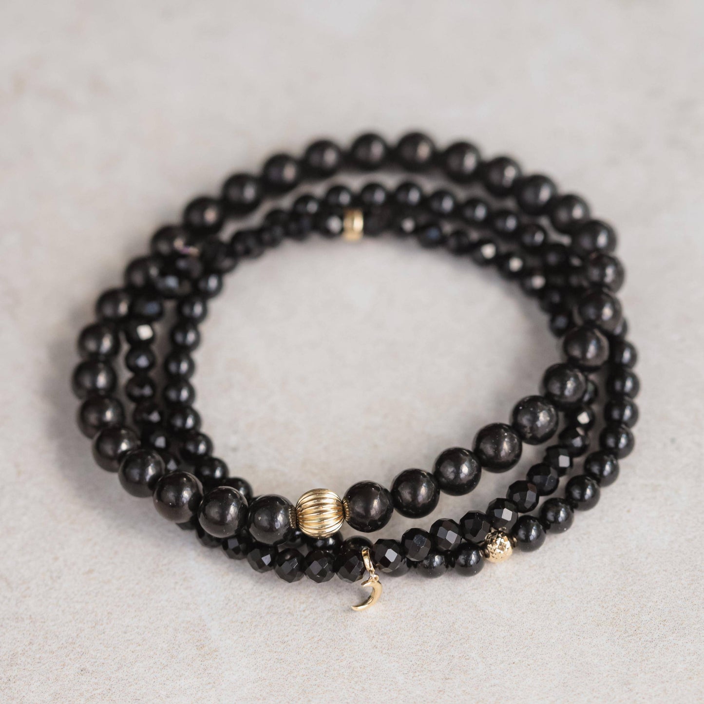 Black onyx bracelet featuring 14K gold accents from Earthly Abundance, showcasing polished black onyx beads and elegant design.