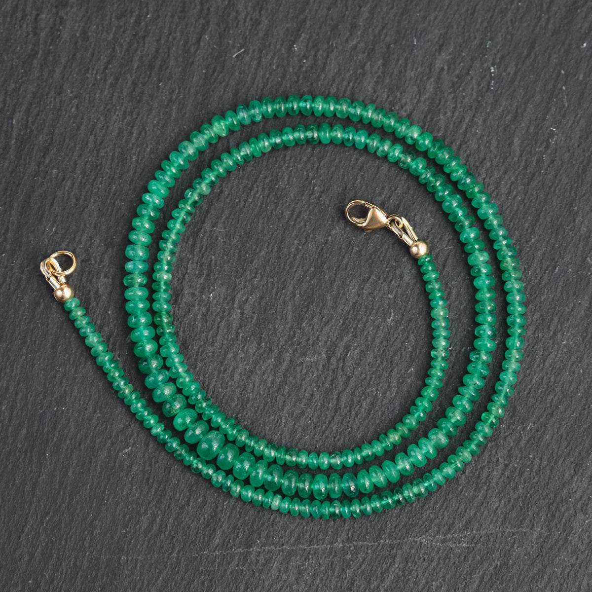 Zambian emerald smooth rondel necklace featuring vibrant green emerald beads on a delicate chain, from Earthly Abundance.