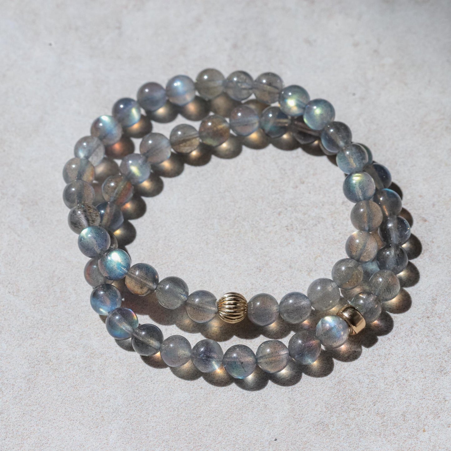 Spiritual Insight Labradorite gemstone from Earthly Abundance showing iridescent blue and green flash on polished stone surface.