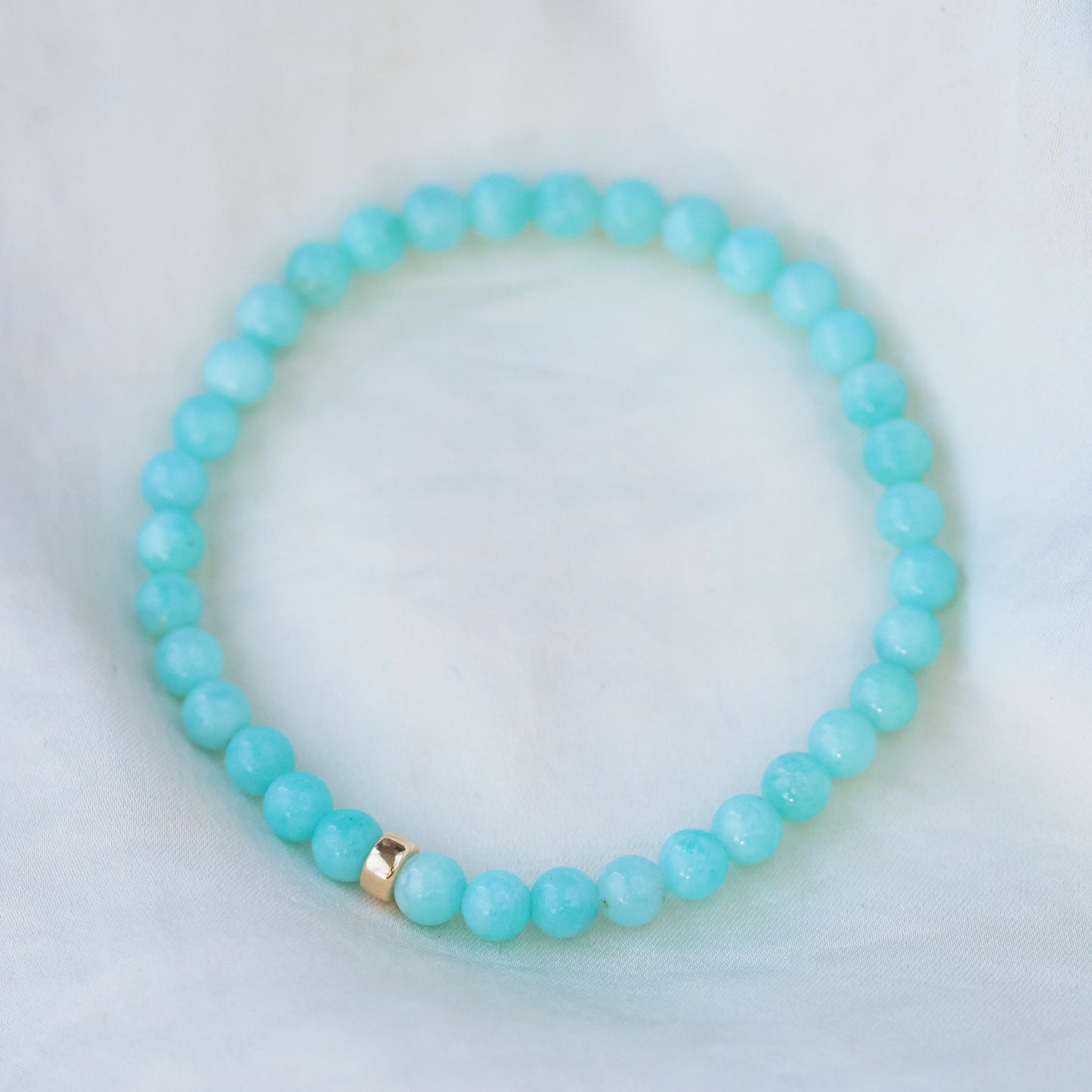 Peruvian Amazonite bracelet with smooth, polished blue-green stones on an elastic band, crafted by Earthly Abundance.
