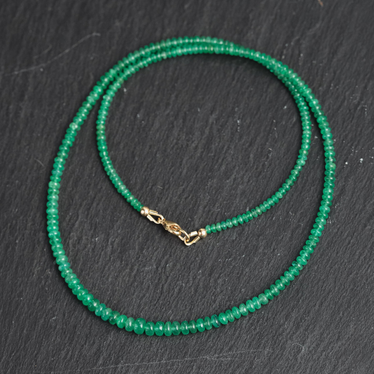 Zambian emerald smooth rondel necklace featuring vibrant green emerald beads strung on a delicate chain, from Earthly Abundance.