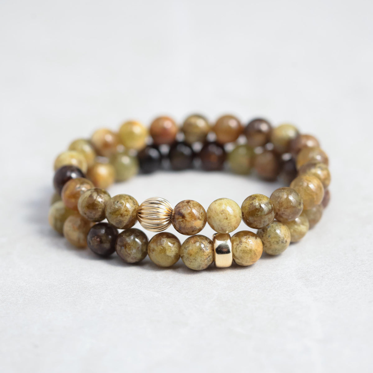 Green garnet bracelet with 14K gold setting, featuring polished green gemstone beads on a delicate gold chain.