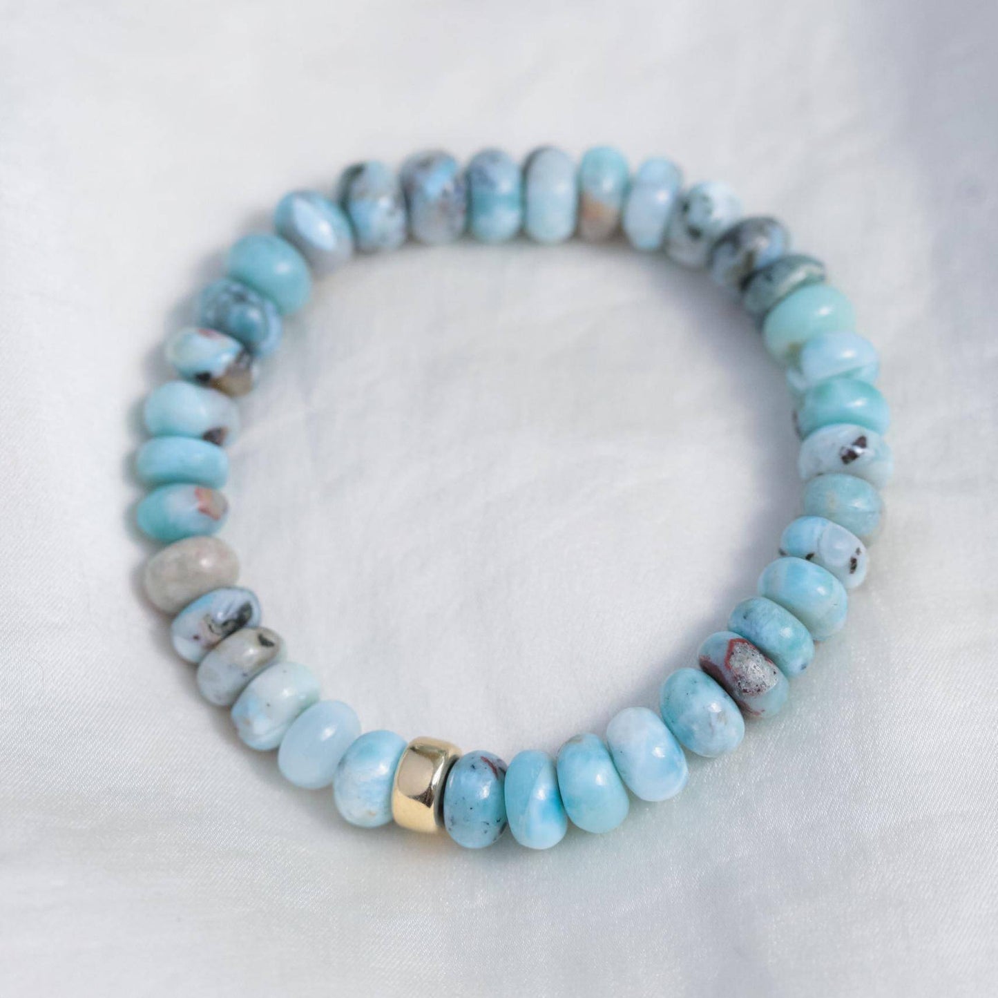 Larimar Smiley Bracelet by Earthly Abundance featuring polished larimar beads and a smiling charm on a white background.