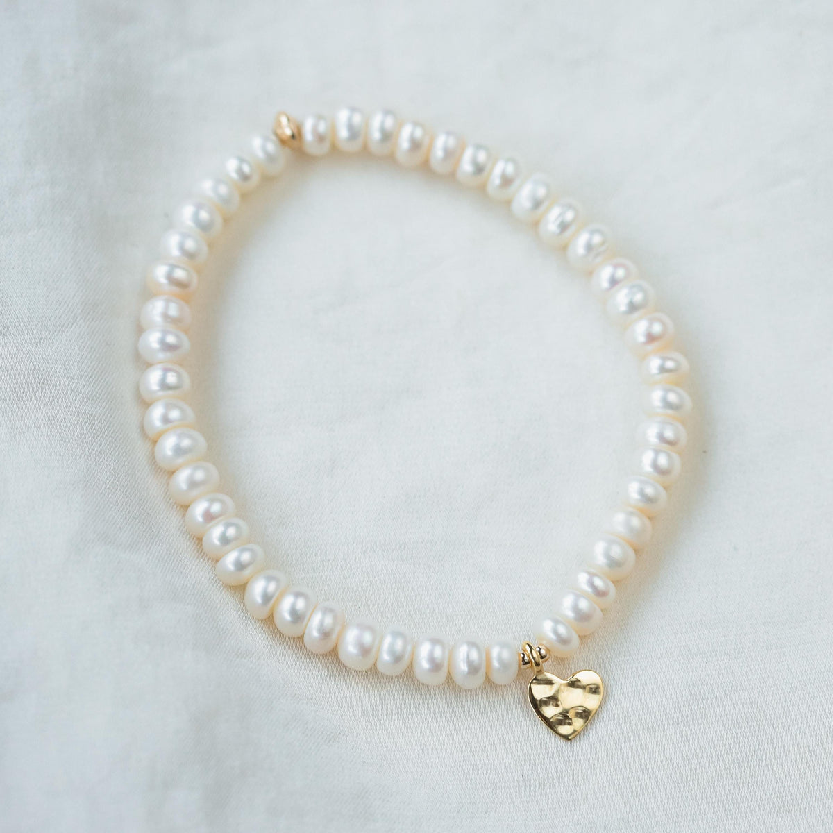 Freshwater pearl bracelet by Earthly Abundance featuring smooth, white pearls on a delicate silver chain.