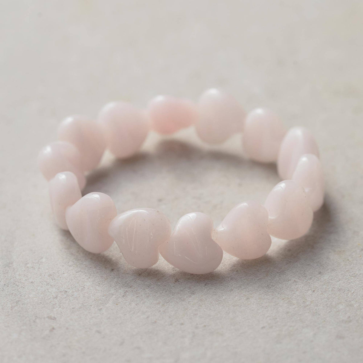 Pink mango calcite heart-shaped bracelet from Earthly Abundance Jewelry featuring polished stone beads and a delicate design.