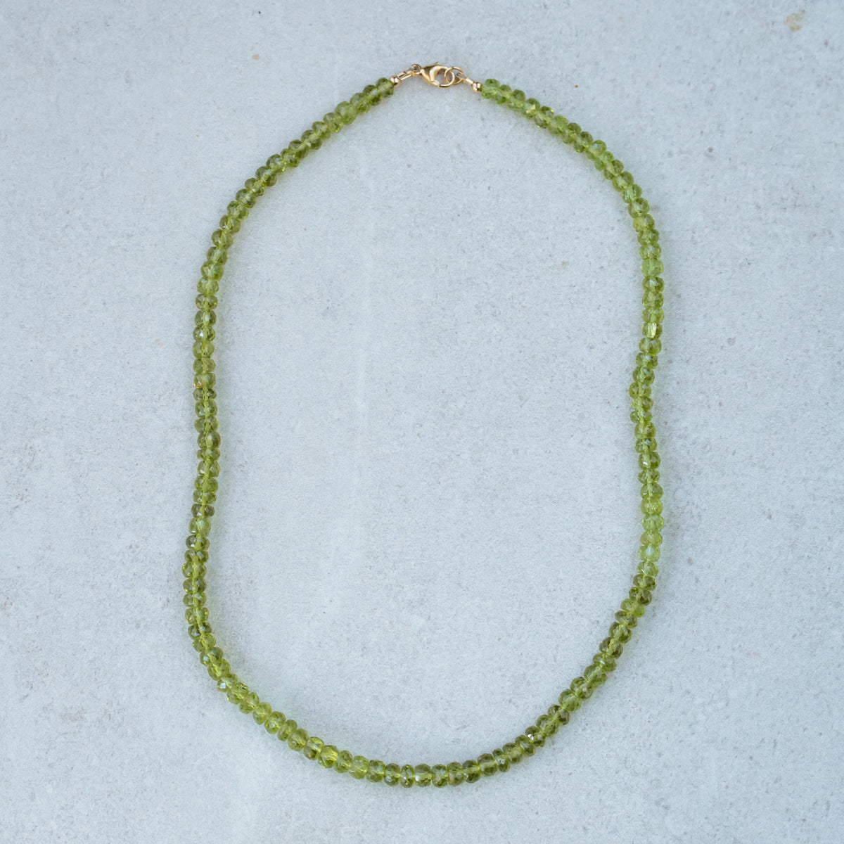 14K peridot necklace featuring a vibrant green gemstone on a delicate chain, crafted by Earthly Abundance.