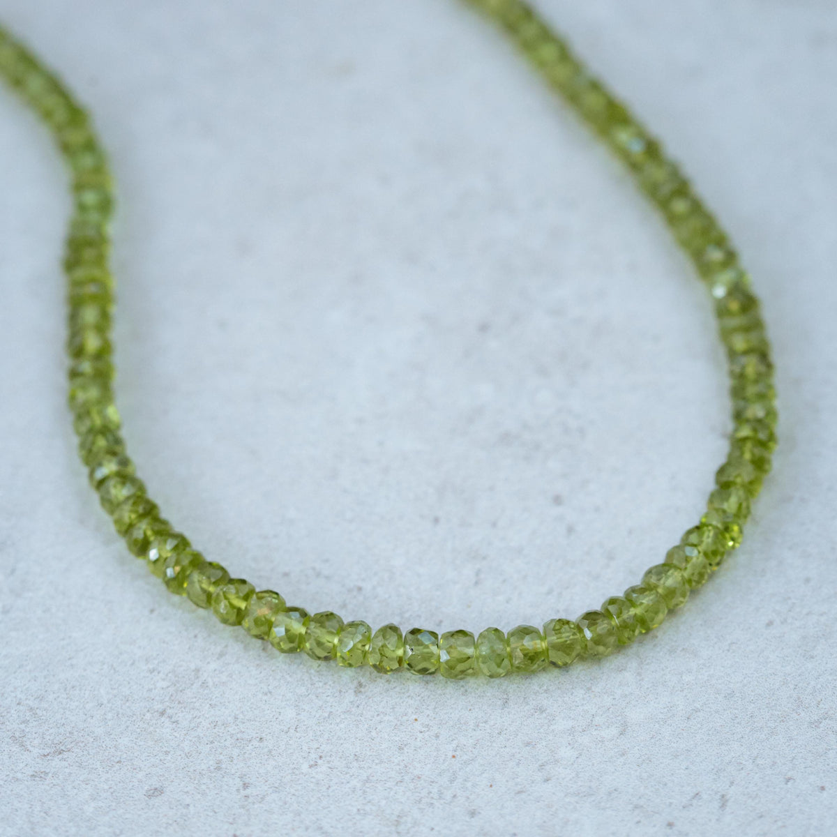 Peridot necklace with 14K gold chain from Earthly Abundance, featuring a vibrant green gemstone pendant.