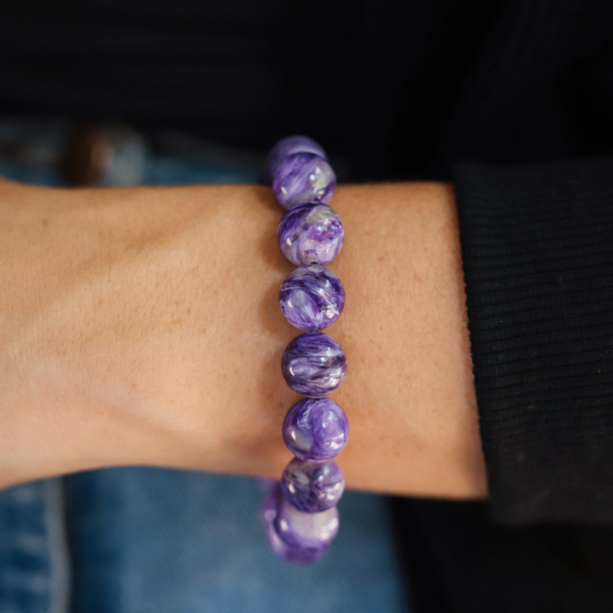 AAAA+ grade Charoite 12mm gemstone bead from Earthly Abundance, shown in a close-up highlighting its vibrant purple color and unique patterns.