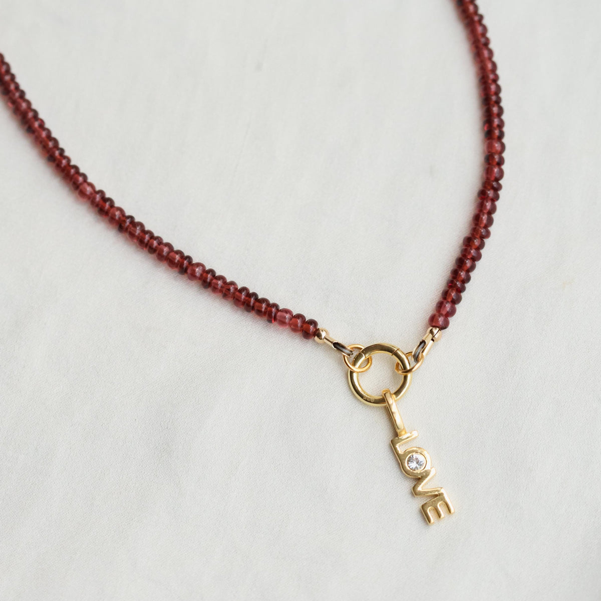 Garnet Love Necklace by Earthly Abundance featuring a deep red heart-shaped garnet pendant on a silver chain.
