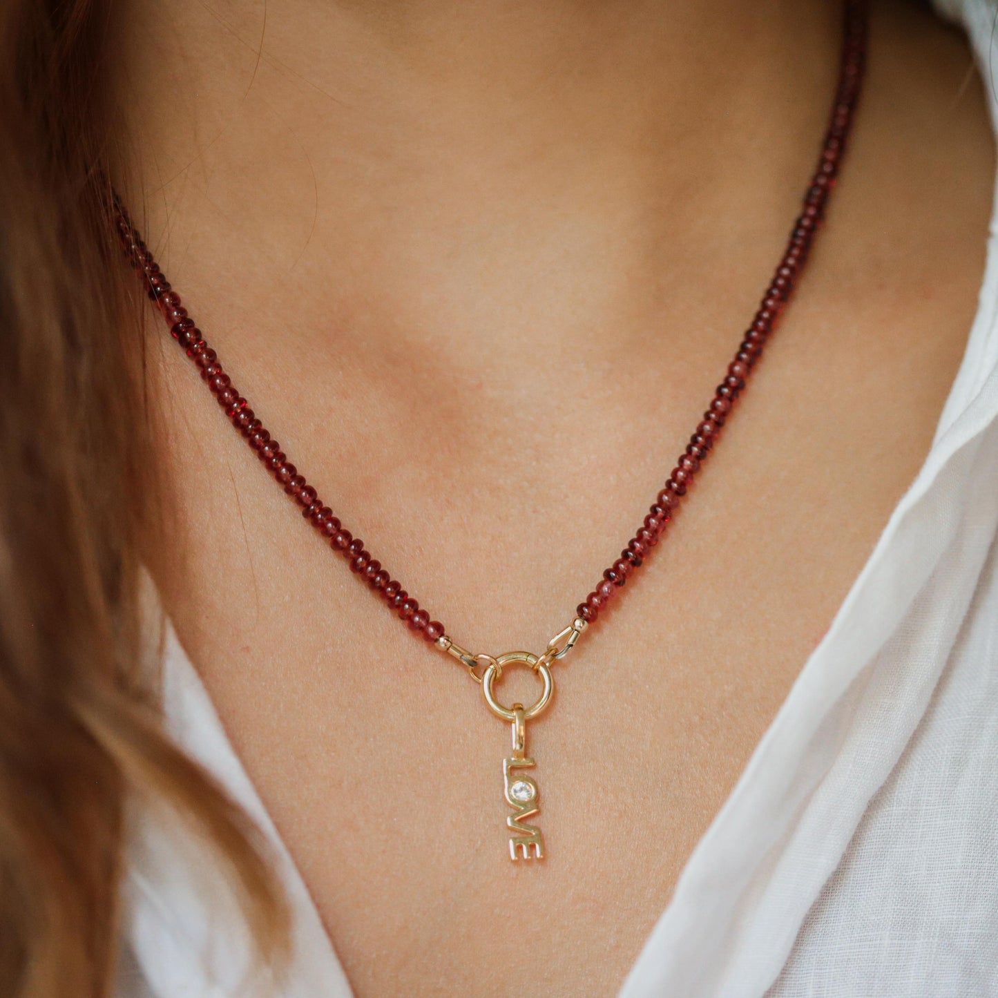 Garnet Love Necklace by Earthly Abundance featuring a deep red gemstone pendant on a delicate chain.