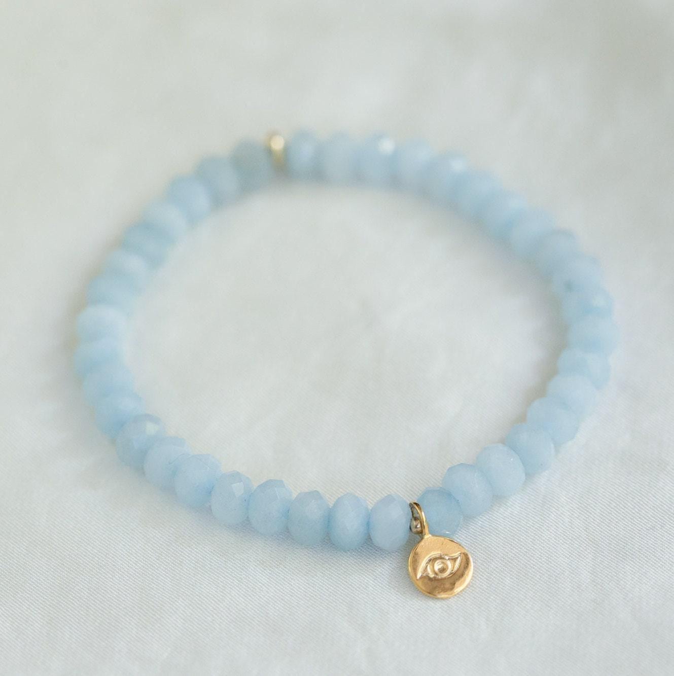 Aquamarine evil eye bracelet from Earthly Abundance Jewelry featuring blue beads and a protective evil eye charm.