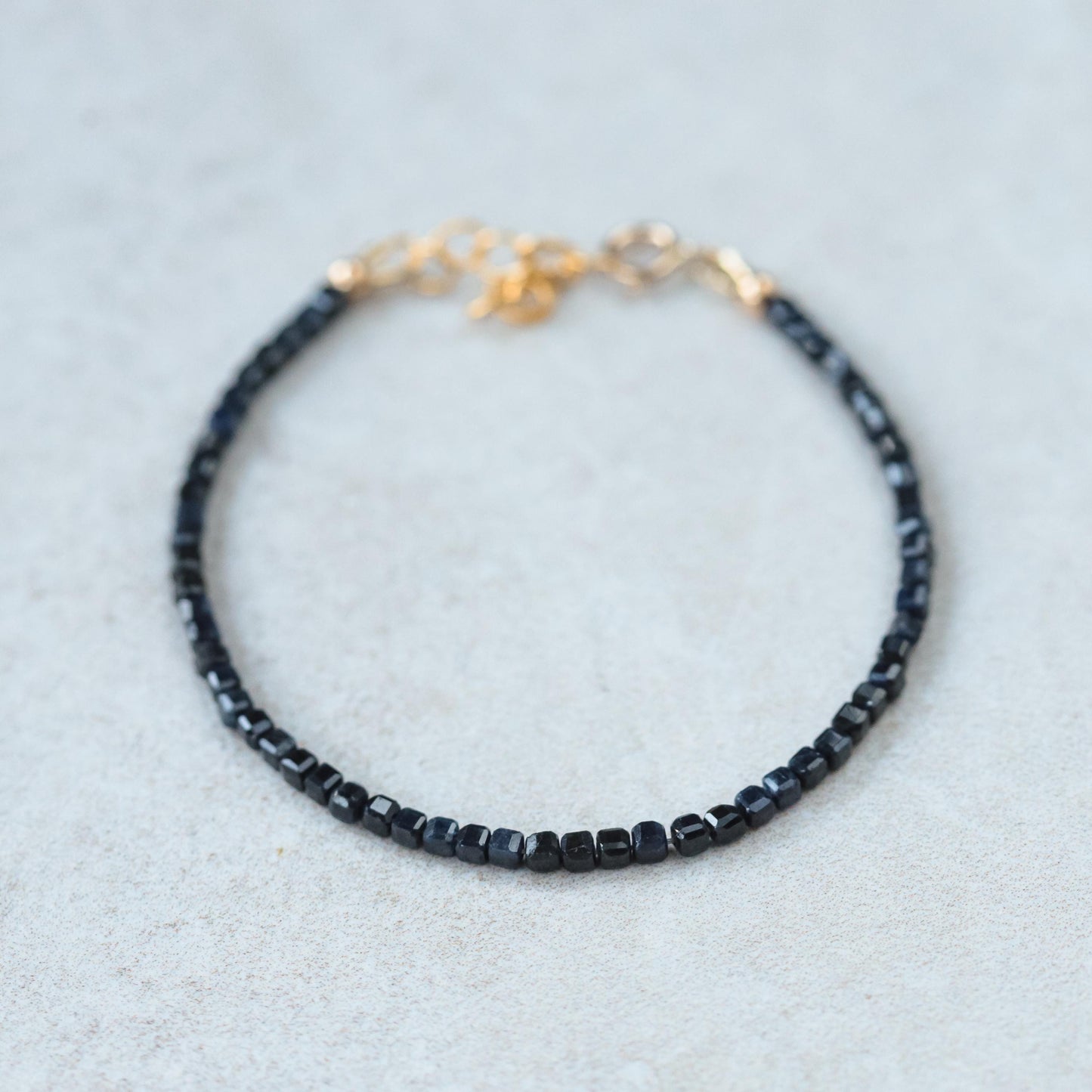 Cube-cut gemstone bracelet featuring 14K gold setting from Earthly Abundance, showcasing vibrant, polished gemstones on a delicate chain.