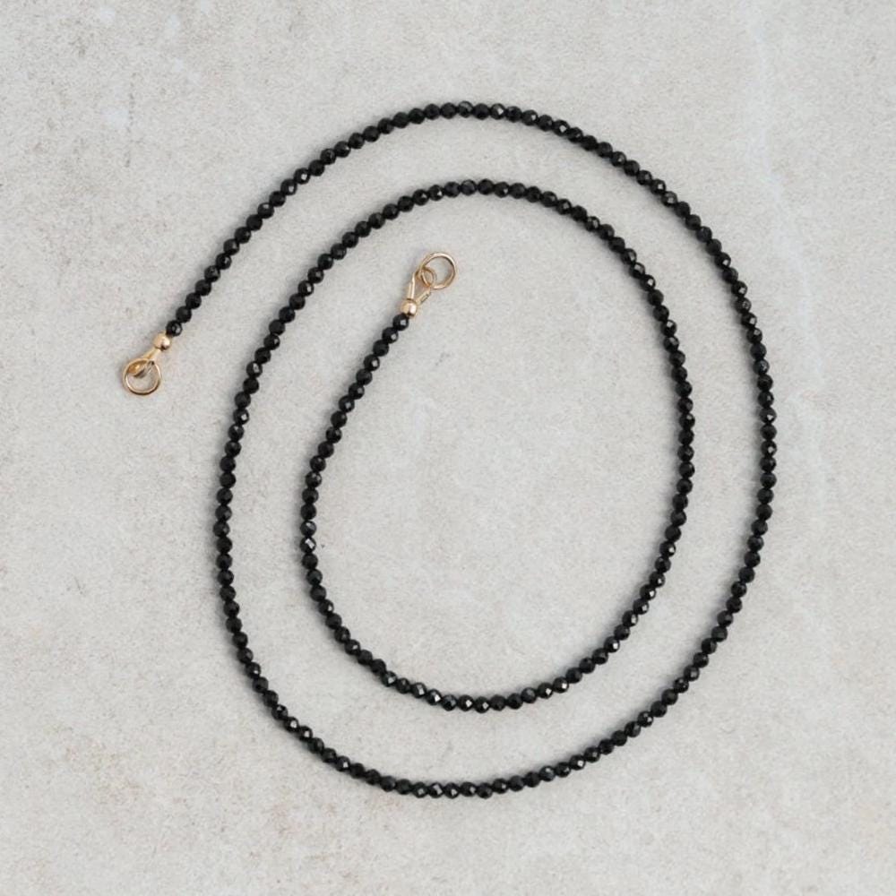 Lore Black Tourmaline Necklace with 14K gold chain from Earthly Abundance, showcasing a polished black tourmaline pendant.