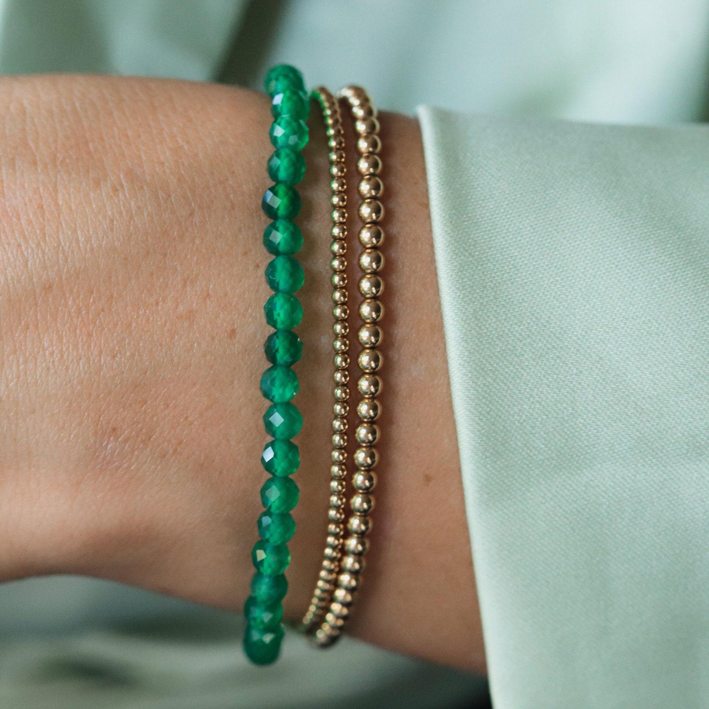Green Onyx bracelet by Earthly Abundance featuring polished oval beads, showcasing a vibrant, natural gemstone jewelry piece.