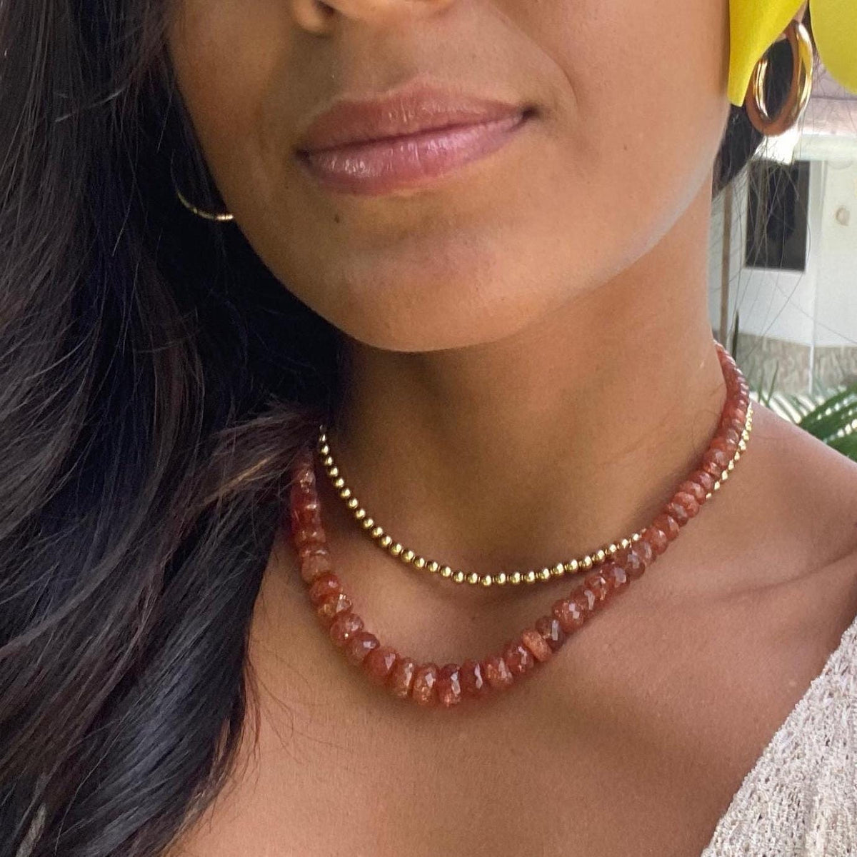 14K Sunstone necklace by Earthly Abundance featuring a polished orange gemstone on a delicate chain.