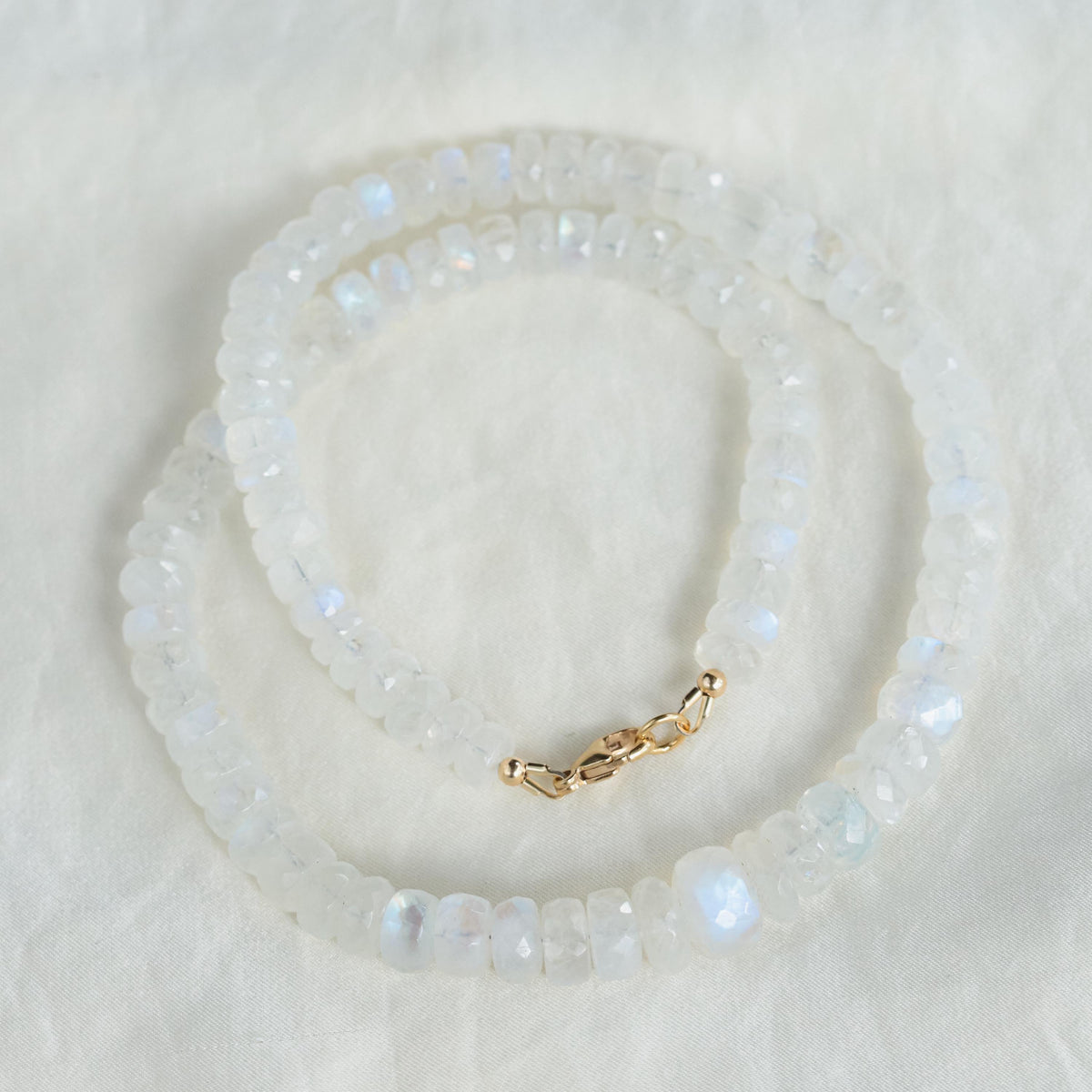 Elegant Moonwater Moonstone Necklace in 14K gold with a glowing moonstone pendant, displayed on a neutral background.
