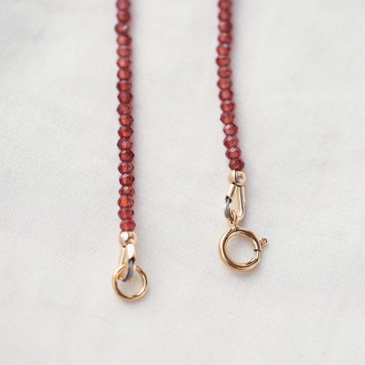 Earthly Abundance garnet 2mm necklace featuring small, round deep red gemstones on a delicate chain.