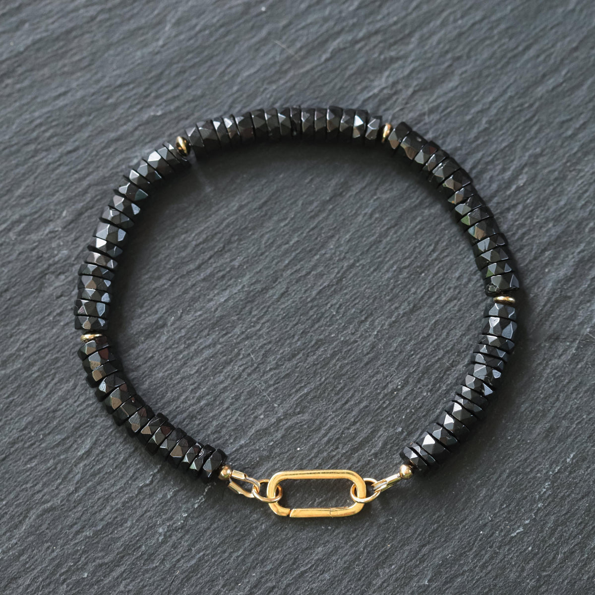 Black Spinel Carabiner Bracelet by Earthly Abundance Jewelry featuring black spinel stones and a sturdy metal carabiner clasp.