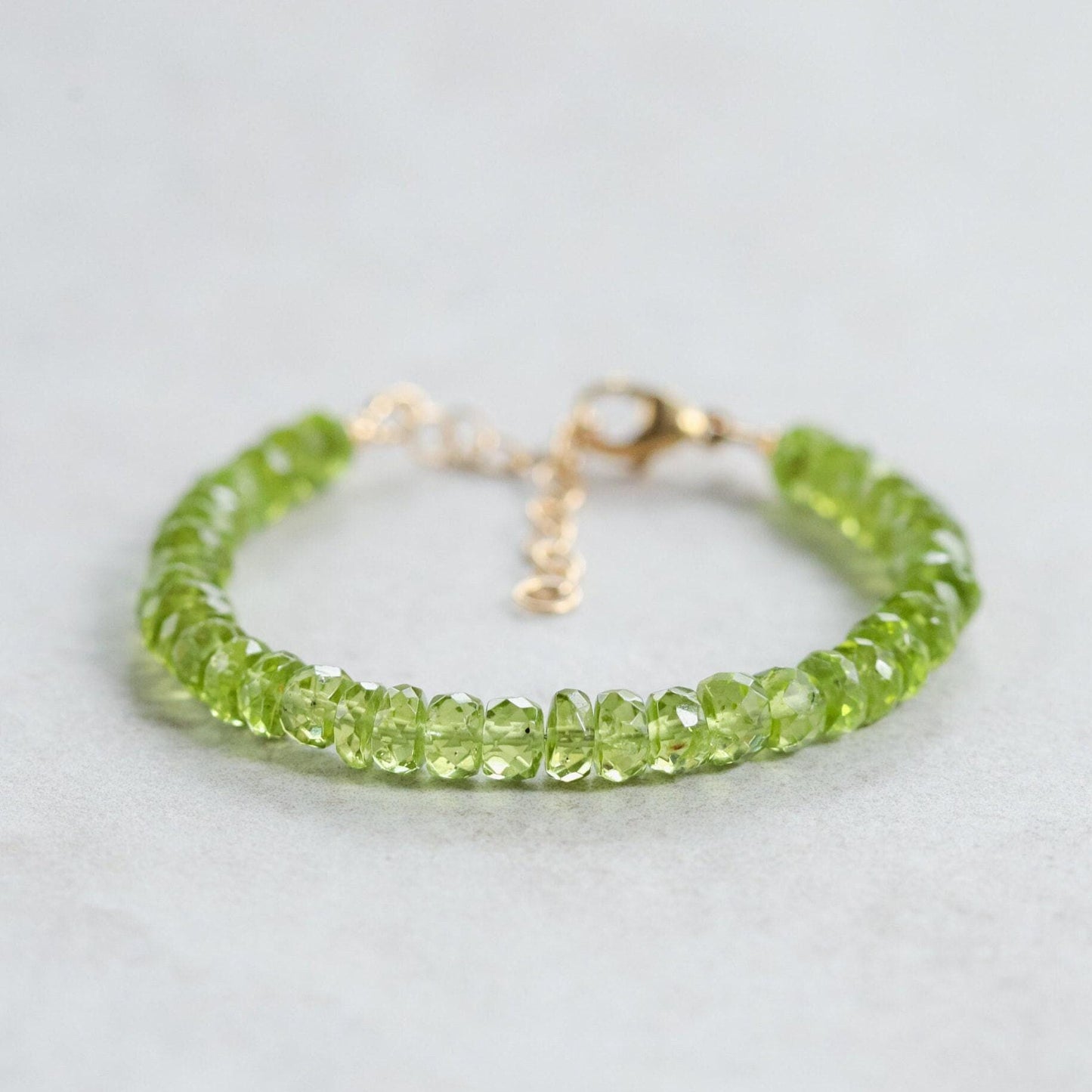Faceted peridot rondel bracelet by Earthly Abundance featuring green gemstone beads on a delicate string.