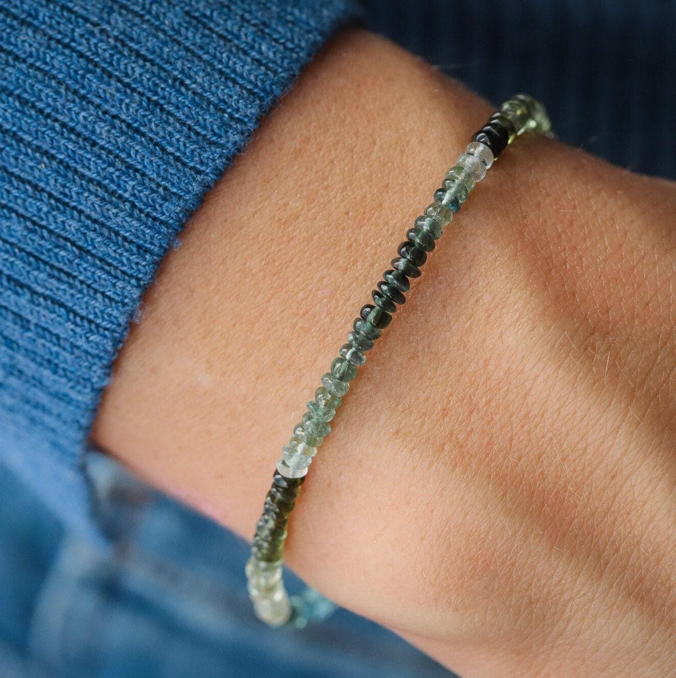 Green and blue tourmaline gemstone from Earthly Abundance Jewelry, showcasing vibrant colors and natural crystal structure.