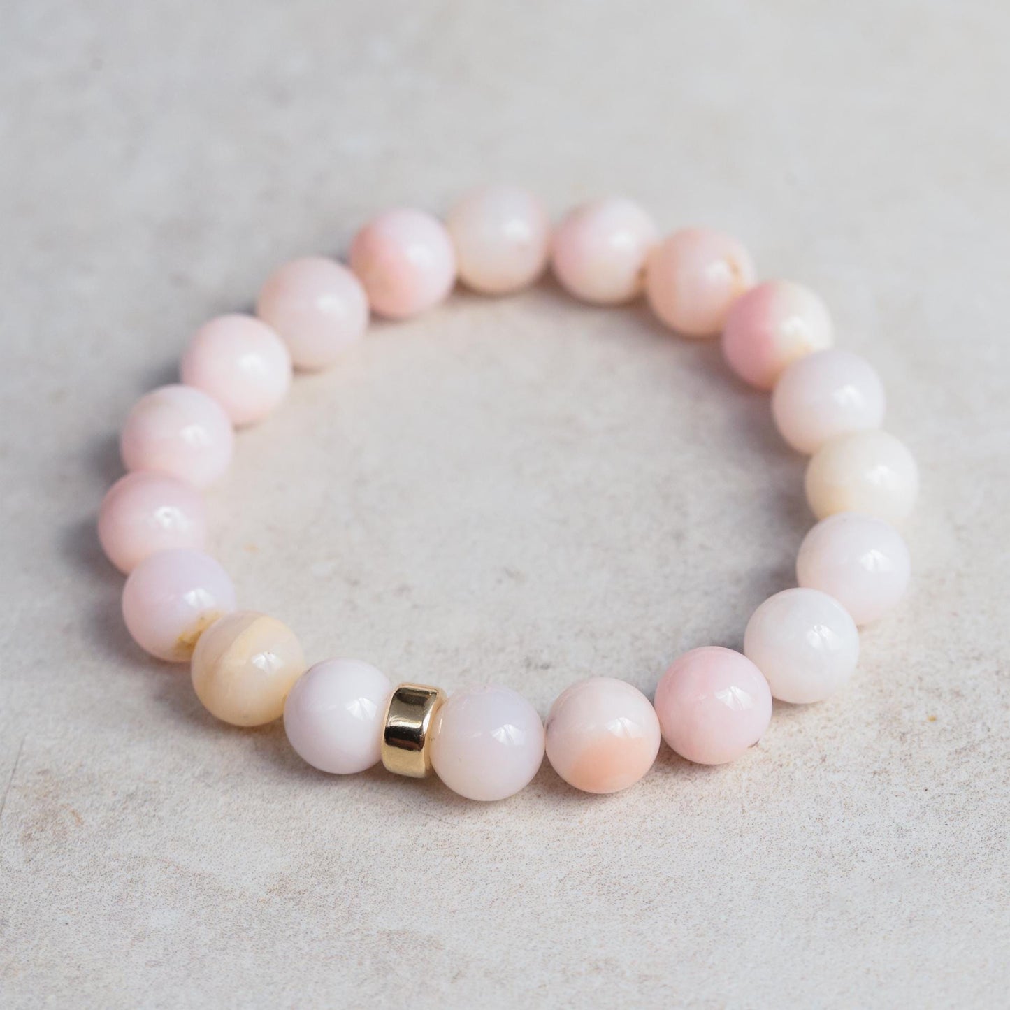 Bold pink opal bracelet featuring 14K gold accents from Earthly Abundance, showcasing smooth pink gemstone beads and elegant design.